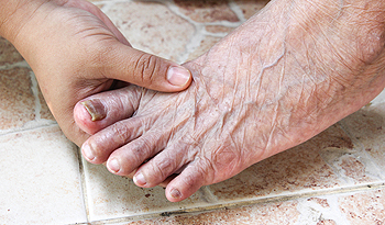 Aging foot patients holding foot