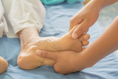 Doctor performing Reflexology on patients foot